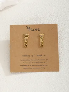 Détail de boucles d'oreilles signe Poissons dorées avec lettrage gothique sur carte