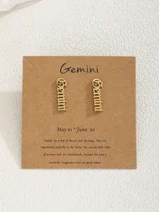 Détail de la boucle d'oreille Gemini dorée sur une carte descriptive en carton
