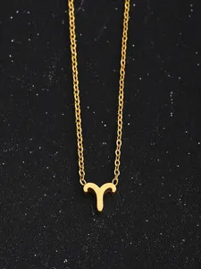 Gros plan du collier pendentif signe Bélier doré sur fond noir effet ciel étoilé