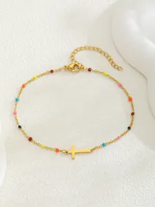Vue détaillée du bracelet en perles dorées avec perles émaillées et pendentif croix