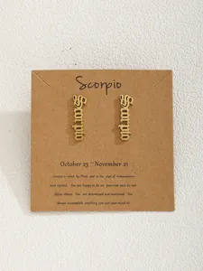 Détail macro d'une boucle d'oreille Scorpion dorée sur sa carte de présentation