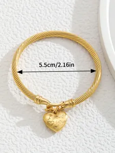 Detail view of gold twisted cable cuff bracelet with heart charm and size dimension