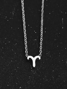 Gros plan du collier signe du zodiaque Bélier argenté sur fond effet ciel étoilé nocturne