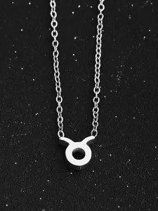 Détail du collier avec pendentif signe du zodiaque Taureau argenté sur fond noir étoilé élégant