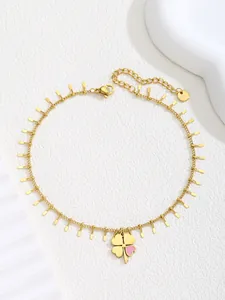 Detailed macro view of a gold clover anklet with one pink petal and s.steel tag