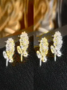 Detailansicht goldener Ohrringe in Blütenform mit funkelnden weißen Kristallen für Damen