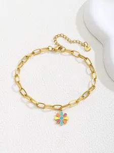 Detail of gold link chain anklet featuring a colorful enamel daisy flower charm and lobster clasp