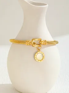 Detail of 18K gold plated cuff bracelet with Roman numeral charm and pearl inlay
