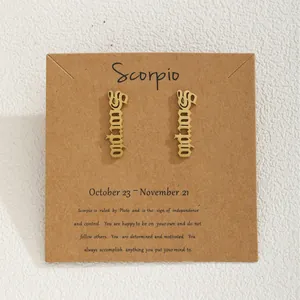 Boucles d'oreilles Scorpion gothiques dorées présentées sur une carte en papier kraft