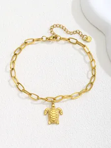 Macro detail of gold sea turtle pendant with minimalist geometric chain and lobster clasp