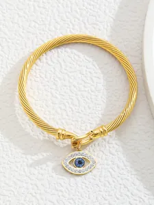 Detailed close-up of 18K gold-plated twisted cable cuff bracelet with Evil Eye charm