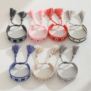 Handmade woven evil eye charm bracelets with colorful fringe tassels in seven vibrant colors