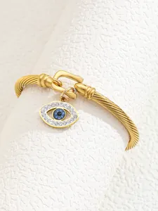 Detailed shot of 18K gold-plated cuff featuring a blue crystal Evil Eye charm