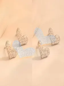 Makro-Detail von herzförmigen Goldsteckern mit Mikropavé-Besatz aus Zirkonia-Kristallen