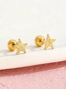 Vista macro degli orecchini a stella dorata con glitter e chiusura a sfera a vite