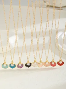 Détail de pendentifs coquillages colorés avec perles sur colliers plaqués or