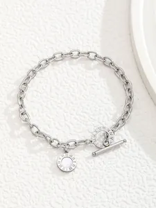 Macro detail of silver link chain bracelet with Roman numerals and white shell pendant