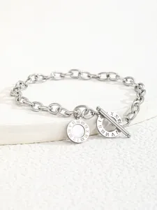 Macro view of silver chain bracelet featuring OT clasp with Roman numeral engraving