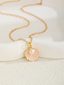 Détail du collier en or avec pendentif coquillage en émail rose et perle blanche