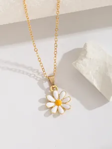 Détail macro du pendentif fleur marguerite blanche avec centre jaune et chaîne dorée
