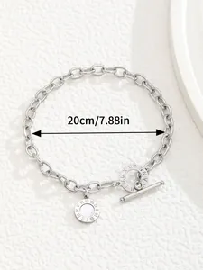 Detailed macro view of silver OT clasp bracelet with Roman numeral engraved disc charm