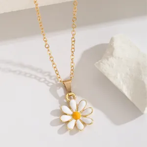 Collier élégant marguerite dorée avec émail blanc sur un socle en pierre blanche texturée
