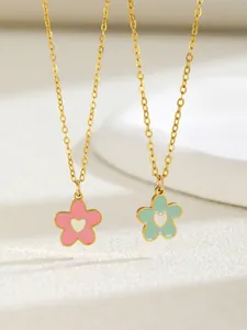 Detailed macro view of pink and green enamel flower necklaces with gold heart centers