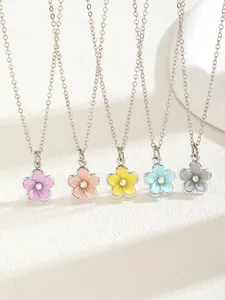 Detail of colorful five-petal flower necklaces with crystal centers on white platform