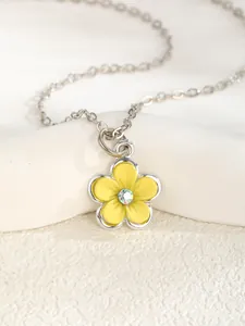 Macro detail of yellow flower pendant necklace with silver edges and centered crystal