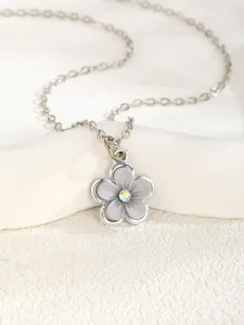 Close-up of a silver flower pendant necklace with gray petals and a sparkling AB crystal center