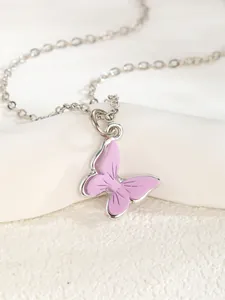 Macro detail of silver O-chain necklace with a purple enamel butterfly pendant