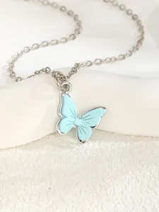 Macro shot of silver-tone chain necklace with light blue butterfly enamel pendant charm
