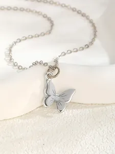 Close-up of a silver butterfly pendant with enamel wings on a delicate cable chain