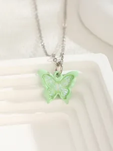 Detailed close-up of light green butterfly pendant with shimmering iridescent finish