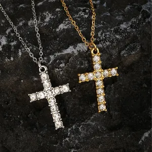 Collares de cruz brillantes en oro y plata con diamantes de imitación sobre fondo de piedra