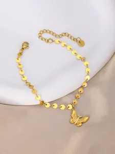 Detail of gold butterfly pendant and sequin chain on silk background for jewelry