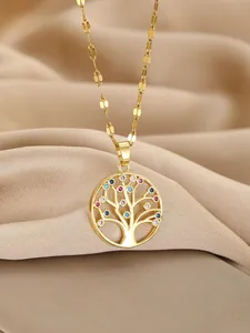 Macro shot of gold Tree of Life pendant with multicolored gems on silk fabric