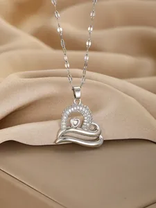 Close-up of heart pendant necklace with white zircons on champagne silk fabric