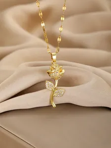 Close-up of golden rose pendant with sparkling white zircons on beige silk fabric