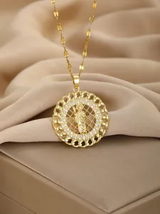 Detail of gold religious Virgin Mary pendant with sparkling rhinestones and rope edge