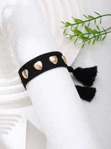 Detail of a black woven choker featuring golden heart studs and delicate fringe tassels