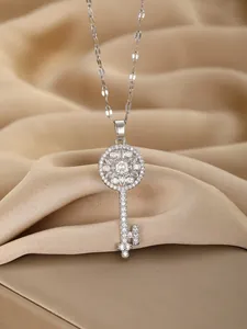 Macro shot of silver flower key pendant with pave zircons on champagne satin