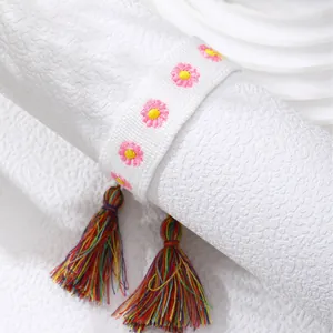 Bohemian woven bracelet featuring pink flower embroidery and colorful fringe tassels
