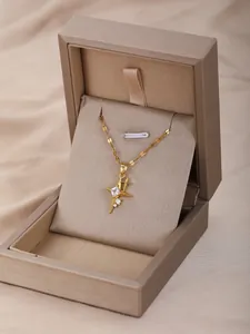 Detalle de un collar de estrella dorada con circón en un joyero premium color champán