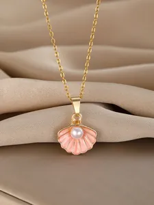 Detail of gold shell necklace with pink enamel and pearl on champagne silk fabric