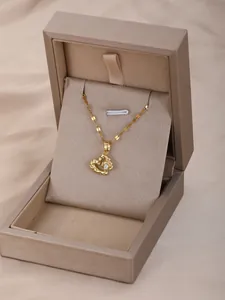 Primer plano del collar con colgante de corazón dorado con textura martillada en joyero