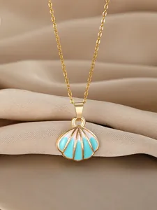 Detail of a gold scallop shell pendant with blue enamel on champagne silk fabric
