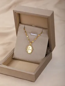Detalle de un collar con colgante Love dorado y circonitas en una caja de regalo de lujo