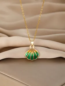 Detail of a gold-toned necklace featuring a gradient green shell pendant on satin