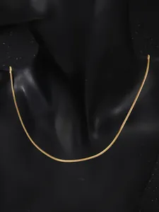 Detalle de una elegante cadena de serpiente dorada sobre un busto de maniquí negro